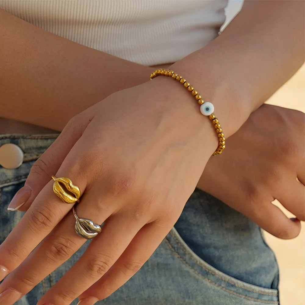 Female model wearing 316L stainless steel beaded evil eye bracelet to showcase fit for small businesses