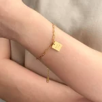 Female model wearing 316L stainless steel logo friendship bracelet to showcase fit for small brand